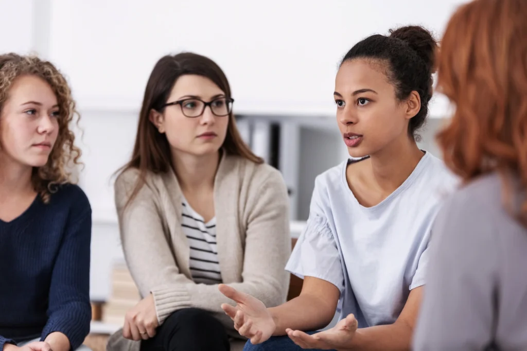 Women participate in a meeting while in transitional living.