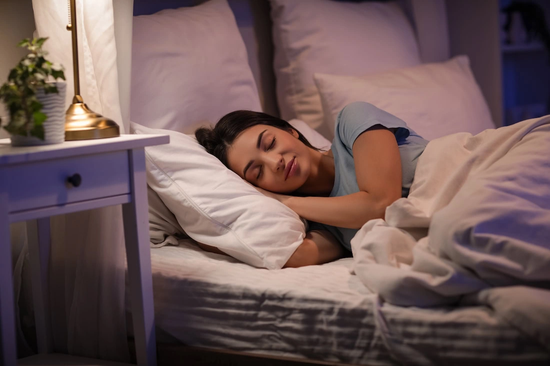 A woman practices sleep hygiene.