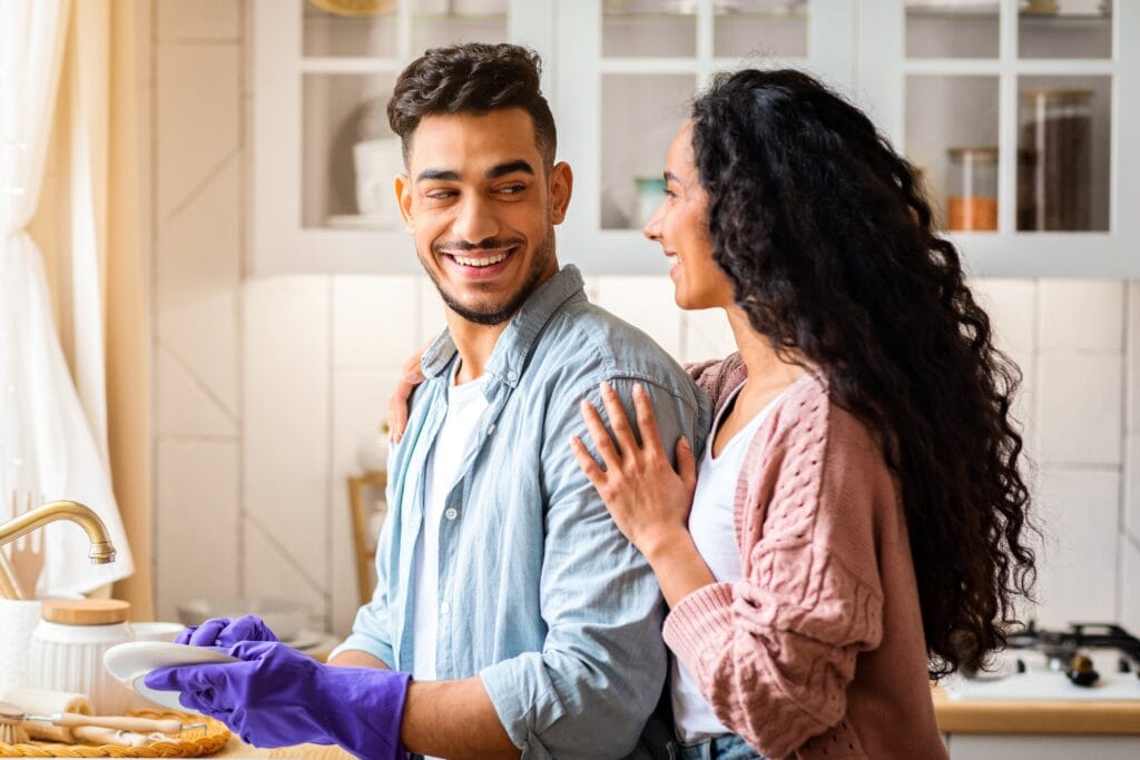 Man doing the dishes for a woman after asking how do gender roles affect women's mental health.